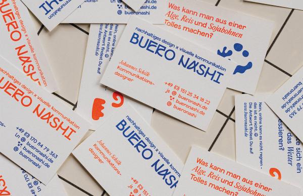 Dies ist ein Bild von den Visitenkarten von BUERO NASHI. Auf den Visitenkarten steht das Logo des Büros sowie die Kontaktdaten. Die verwendeten Farben sind blau und ein leuchtendes Orange
