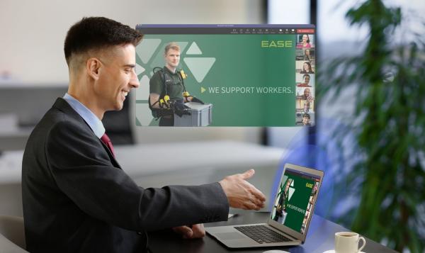 Mann, der auf einen Bildschirm schaut, der ein Online-Meeting zeigt. Im Online-Meeting wird das Video von PACK gebroadcastet.